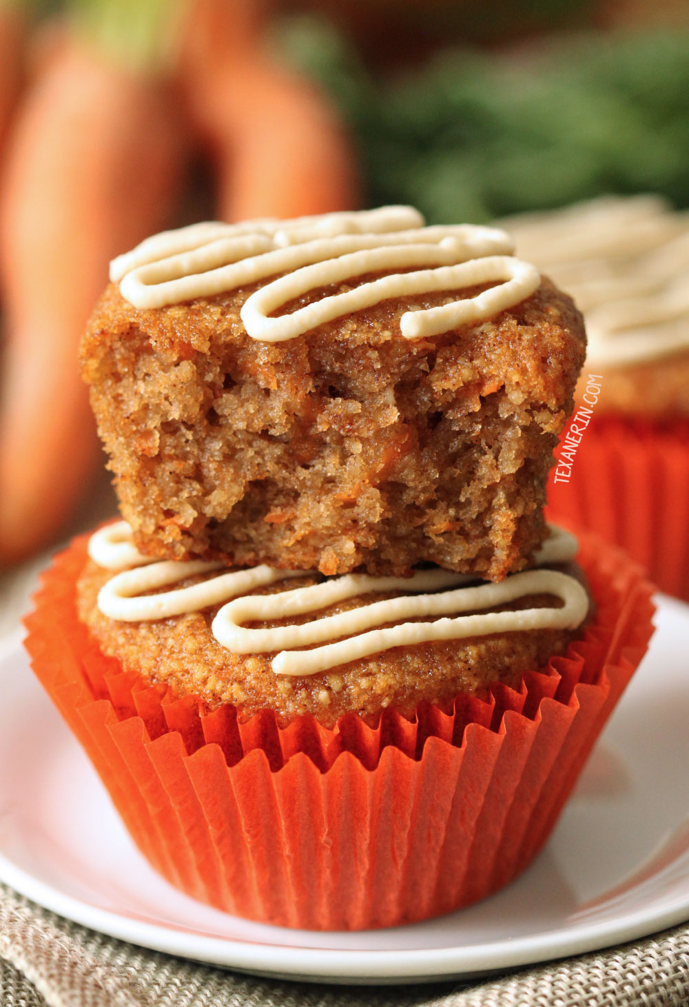 stack of 2 almond flour carrot muffins with bright orange liners