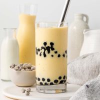 Photo of a tall glass of layered boba smoothie made with bananas, mangos, boba, greek or coconut yogurt and naturally sweetened with maple syrup