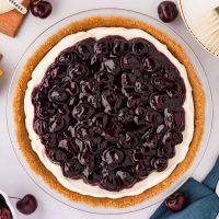 Photo of an easy to make no-bake cherry cheesecake made with a graham cracker crust in a pie pan