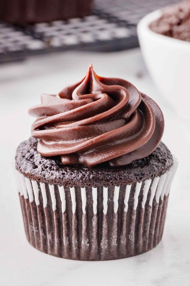 A single chocolate cupcake on a white table