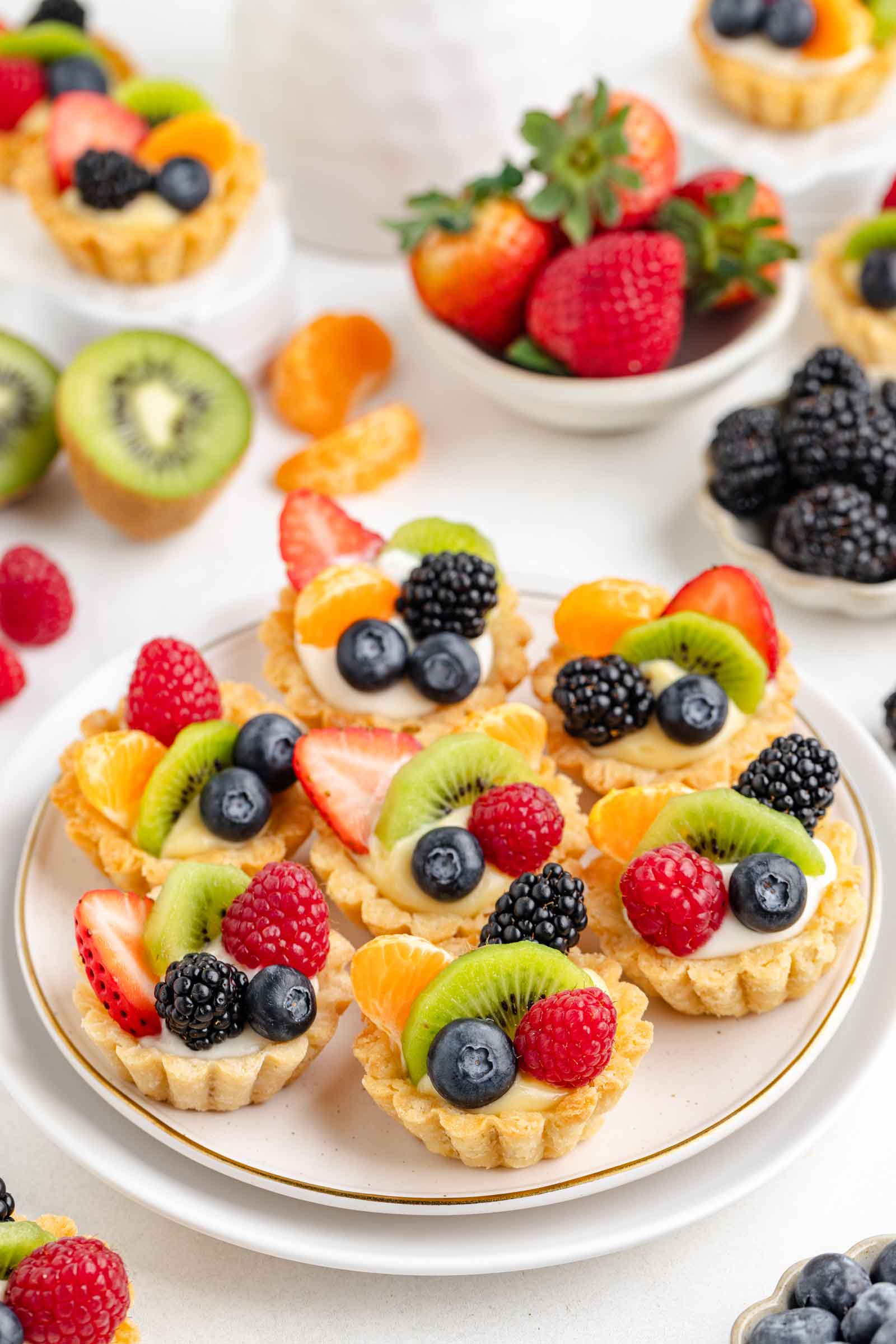 white plate filled with fruit tartlets